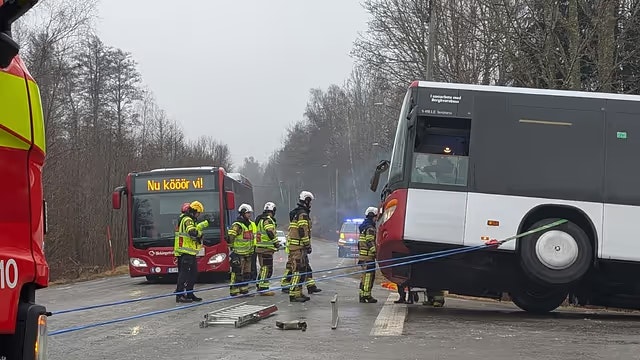 Räddningstjänst hjälper vid olycka med buss och lastbil på landsväg.