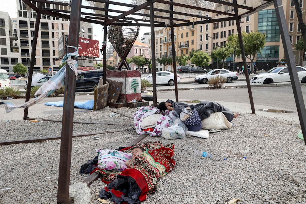 Två flyktingar sover på en trottoar i Beirut