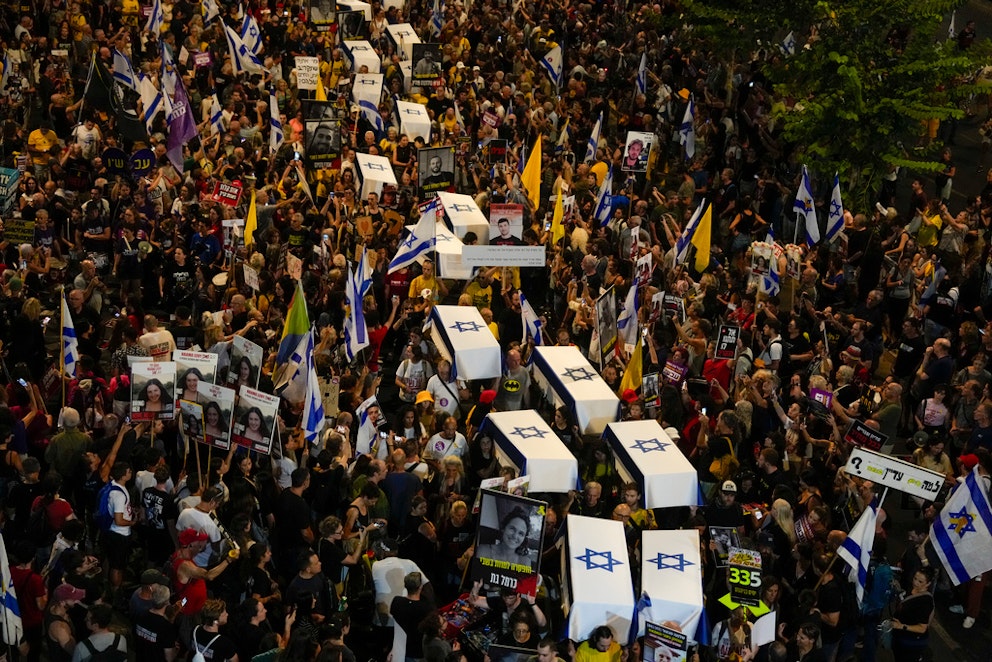 Kistor täckta med israeliska flaggor i Tel Aviv. Offren ska vara 27 personer som suttit gisslan i Gaza. Foto: Ohad Zwigenberg/AP/TT