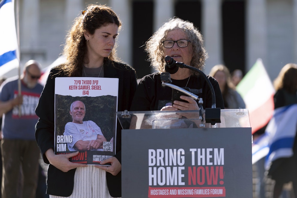  Aviva Siegel, en frigiven gisslan, och hennes dotter Elan håller i ett fotografi av sin far som kidnappades av Hamas-militanter den 7 oktober 2023, talar under en demonstration.