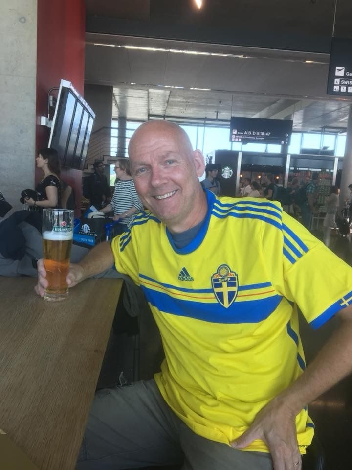 Patrick Lundström iklädd svensk fotbollströja och med en öl i högra handen