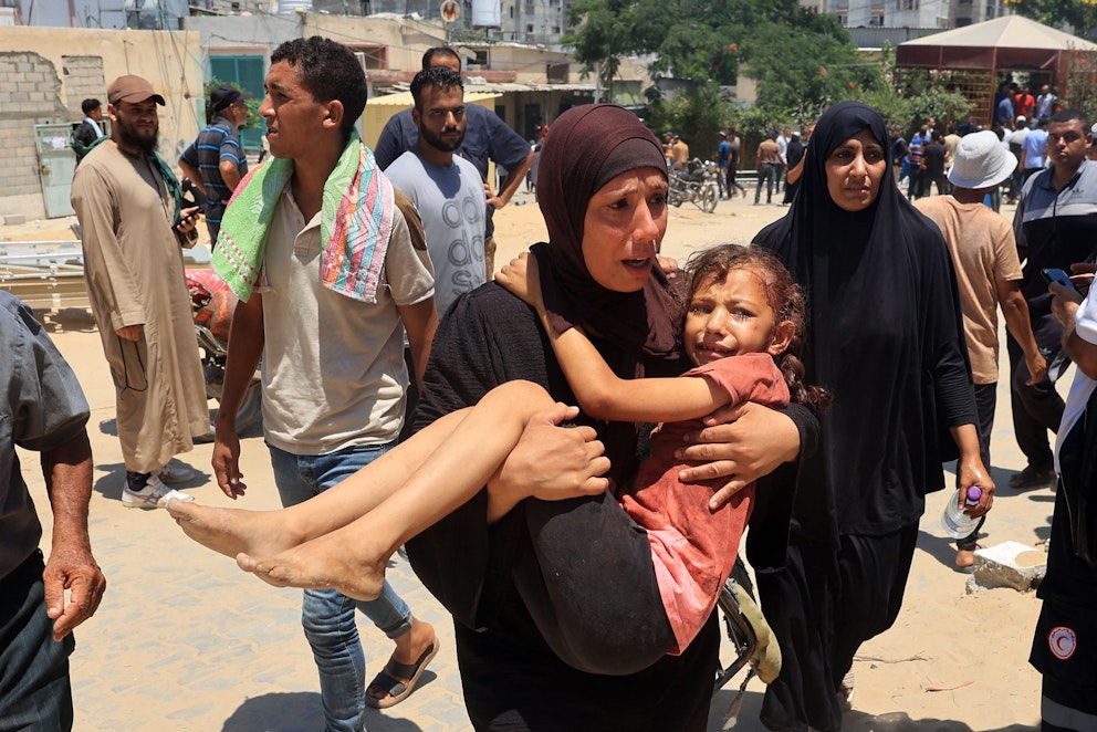 En kvinna bär en flicka som skadats till Nassersjukhuset i Khan Yunis den 13 juli.