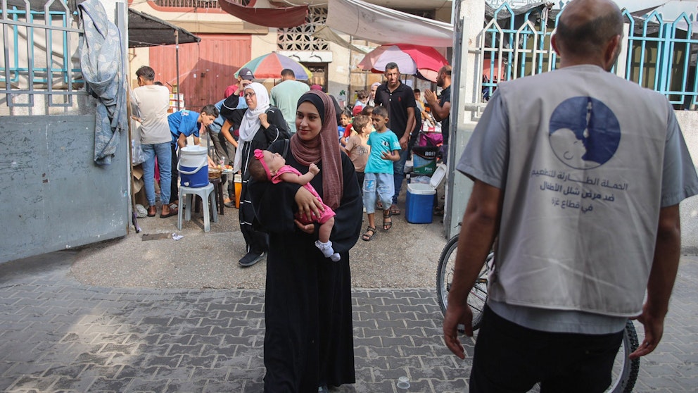 Palestinier lämnar vaccinationskliniken. Foto: Omar al--Qattaa/AFP