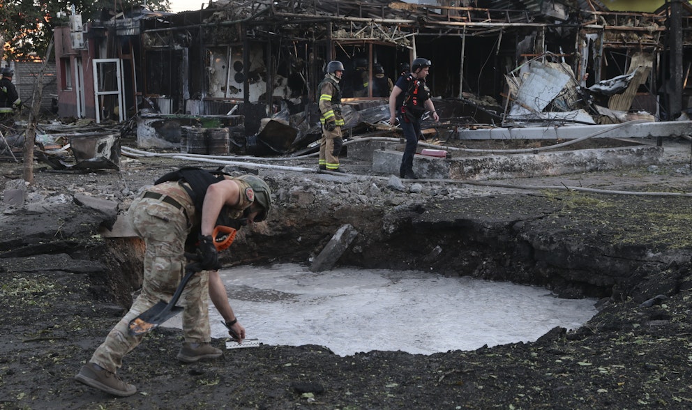 Ukrainsk räddningspersonal inspekterar en krater som uppstått efter en rysk attack i Zaporizjzja den 29 juni. Minst sju personer dog, två av dem barn. 18 personer skadades.
