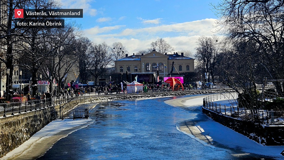 Solsken över Västerås och festlig stämning vid Svartån! Människor samlas längs kajen för att ta del av Melodifestivalens festligheter, medan den frusna ån reflekterar den blå himlen. En dag fylld av musik, glädje och vinterkylig charm.