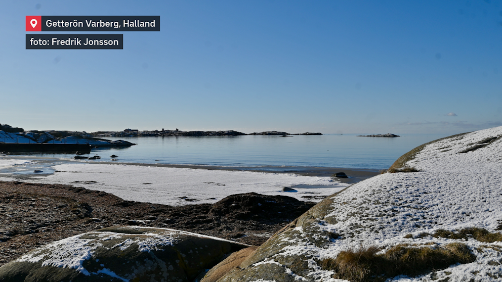 Vintern möter havet vid Getterön. Tunna snötäcken klär klipporna, medan det stilla vattnet speglar en klarblå himmel. En krispig dag vid kusten.