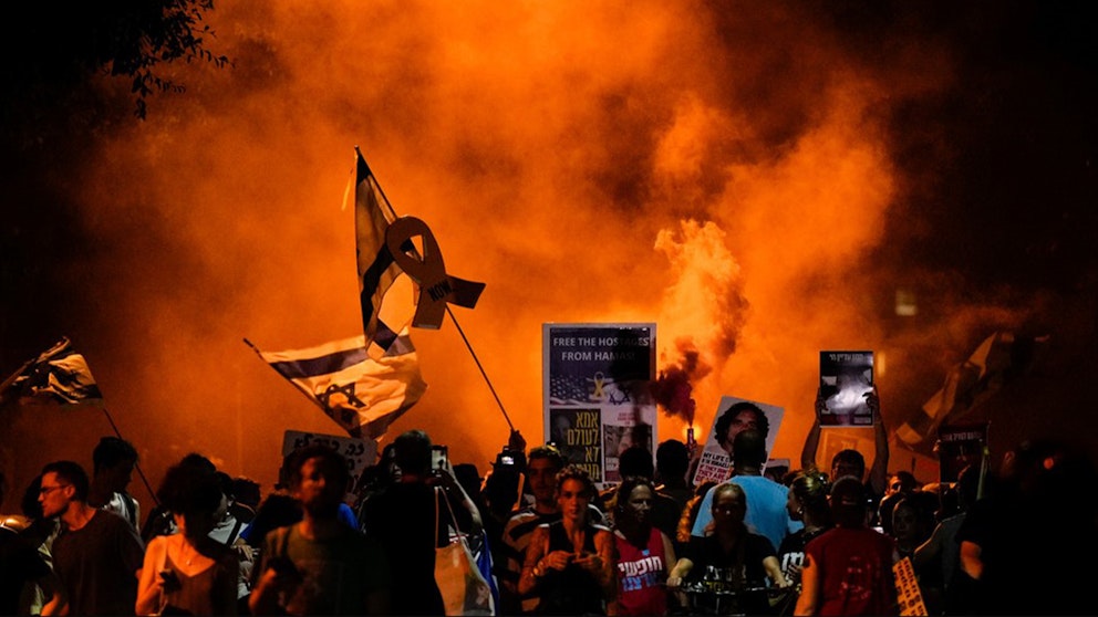 Orange rök stiger från demonstranter i Tel Aviv.