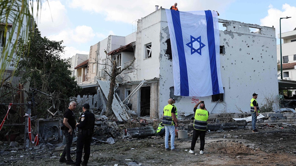 En förstörd byggnad i Kiryat Bialik med en israelisk flagga på.