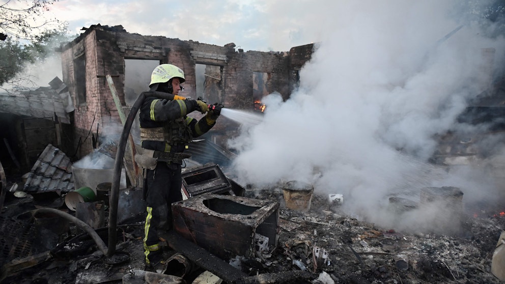 Brandmän släcker en brand i ett bostadshus efter en rysk drönare. 