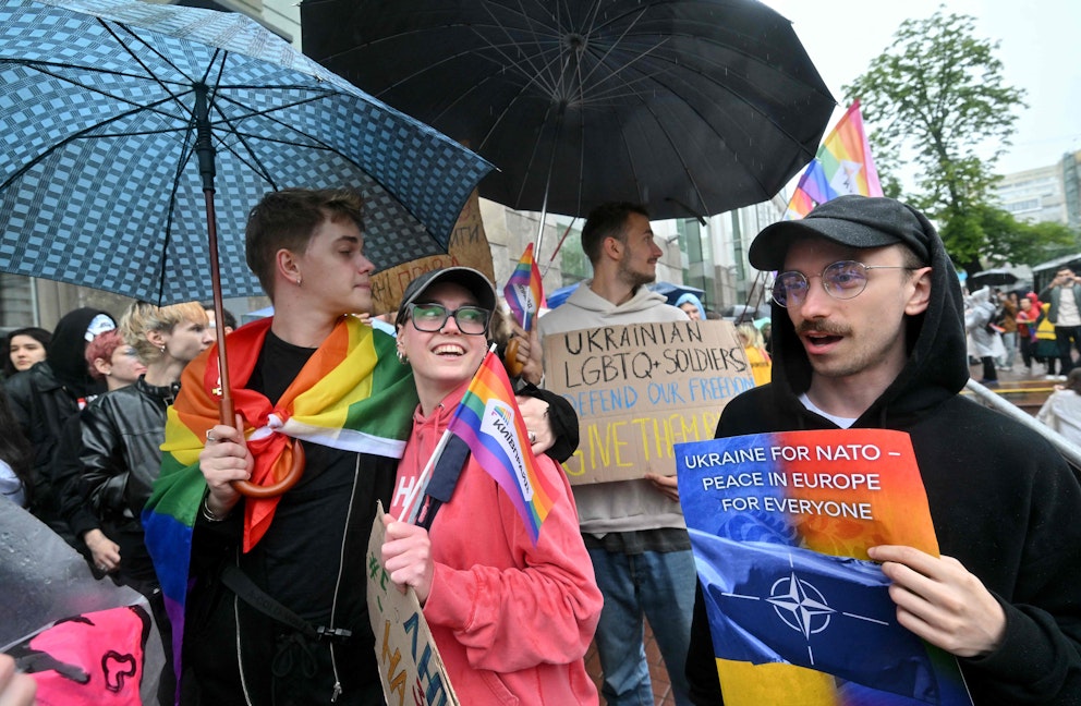 Demonstranter med prideflaggor och budskap
