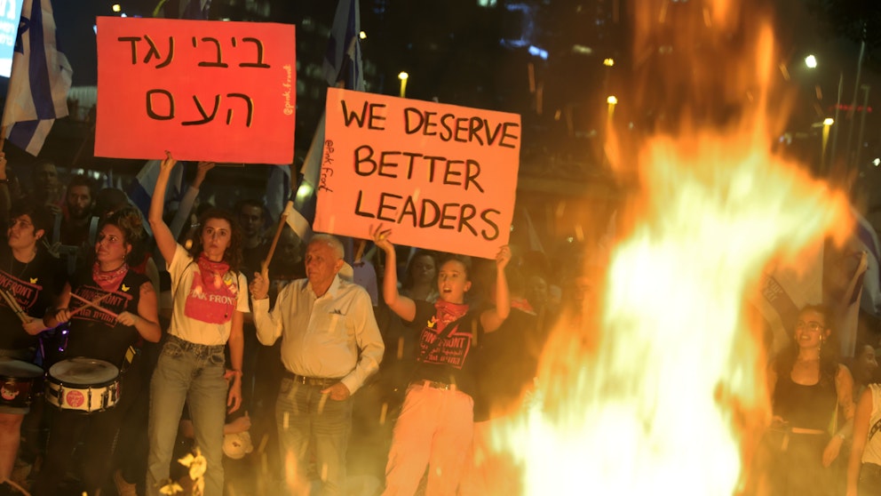 Demonstranter håller upp skyltar i Tel Aviv. Foto: Vassil Donev/EPA/TT