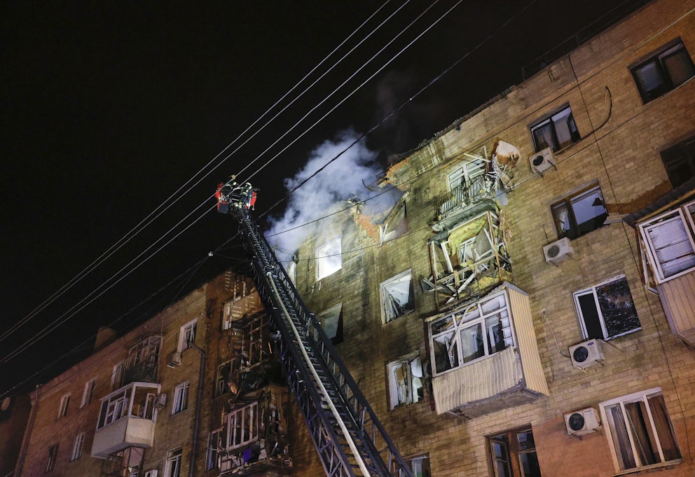 Räddningsarbetare jobbar vid ett bostadshus i staden Charkiv som skadats i en rysk attack. 