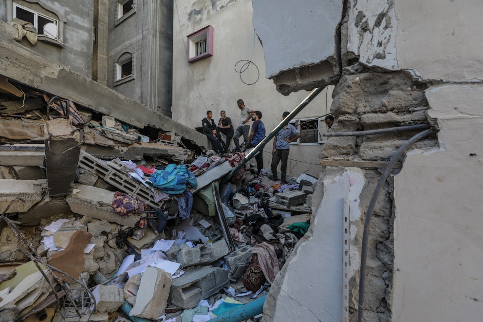 Palestinier söker igenom rasmassorna efter en israelisk attack mot flyktinglägret al-Maghazi. Foto: Mohammed Saber/Epa