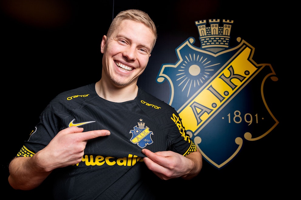 En fotbollsspelare framför klubbmärket AIK.