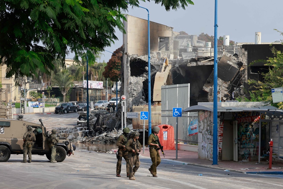 Israelisk militär framför en totalförstörd polisstation