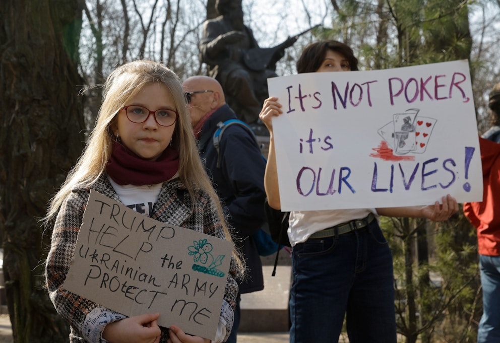 Personer under protest med skyltar om Ukrainas situation.